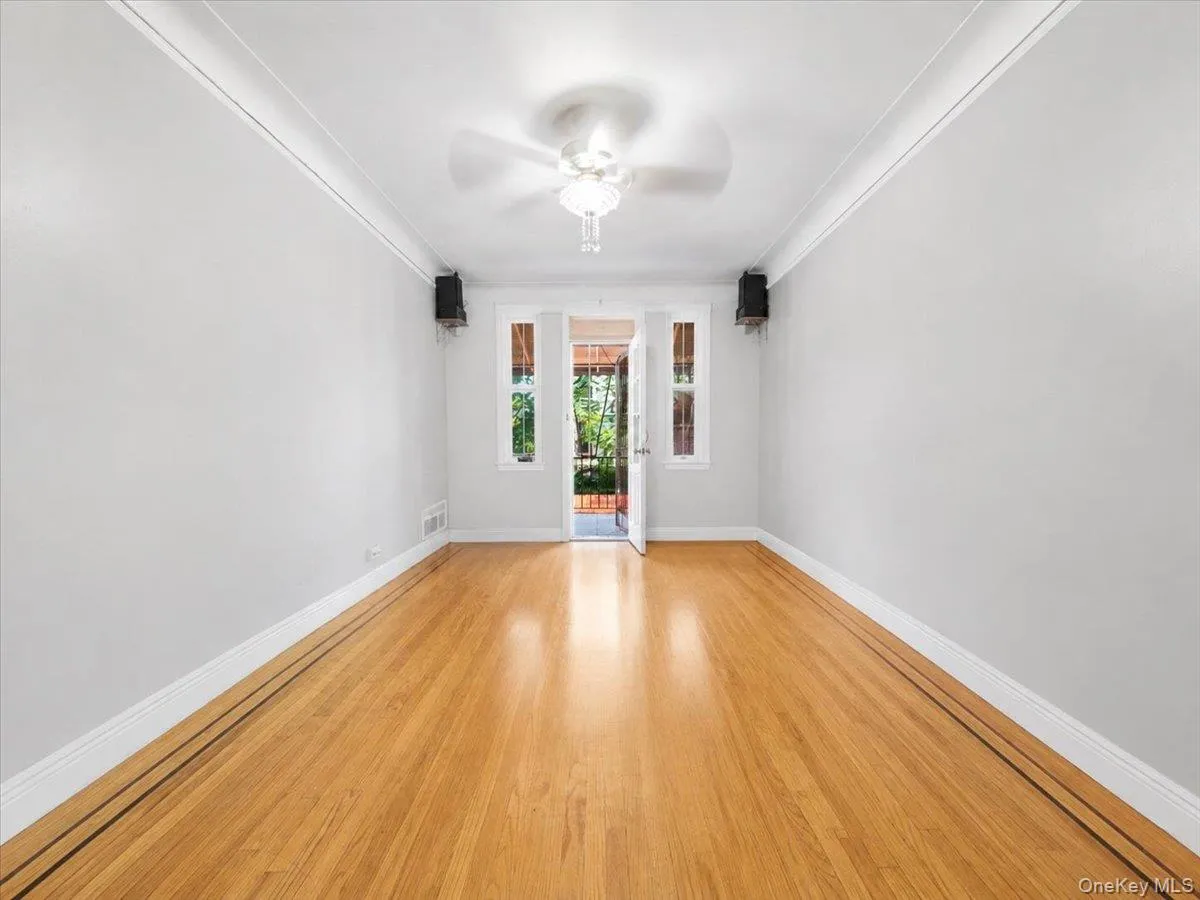 Hardwood flooring with decorative inlay, ceiling fan with light fixture, and crown molding Hardwood flooring with decorative inlay, ceiling fan with light fixture, and crown molding