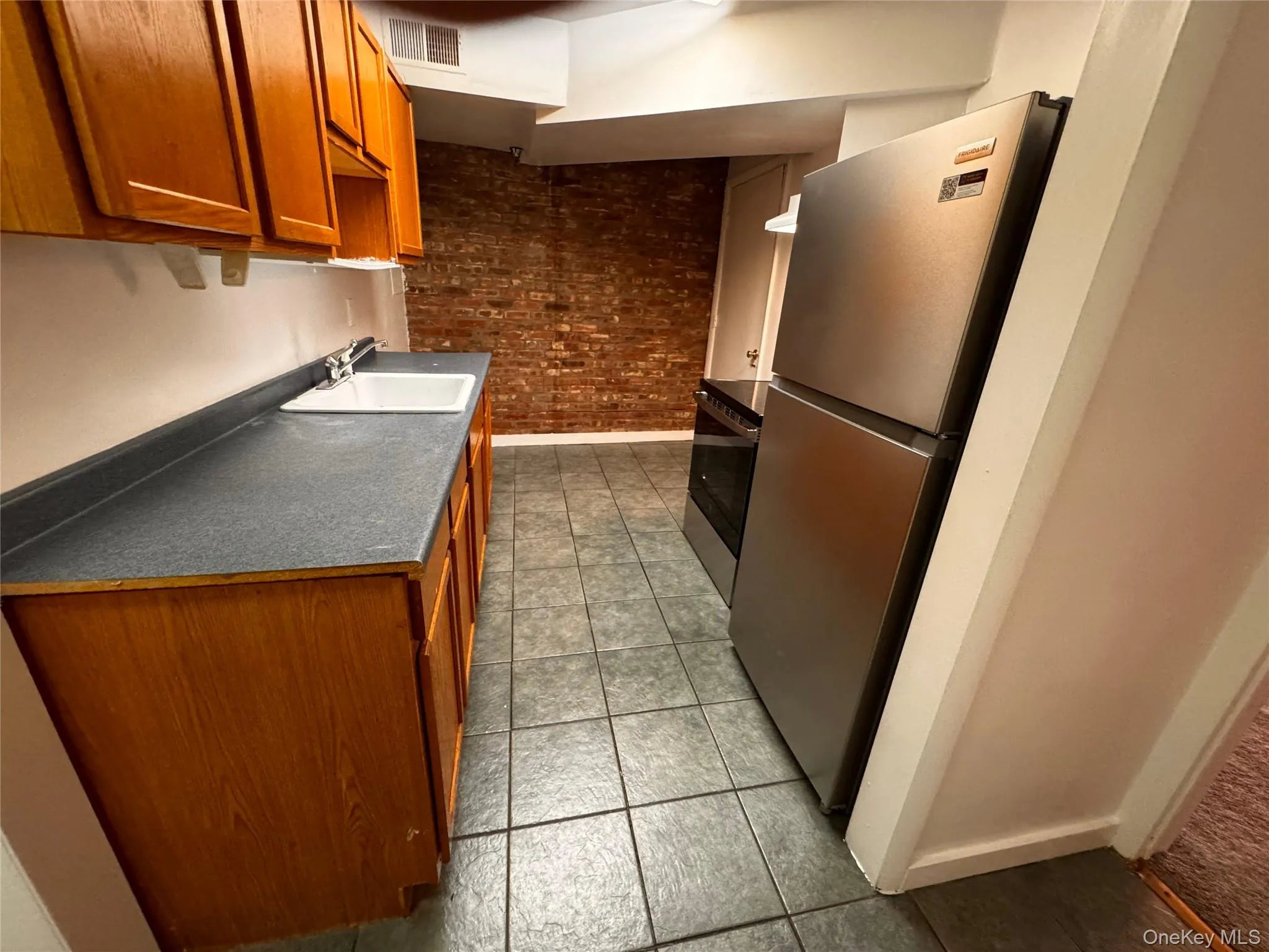Kitchen from hallway. New refrigerator and electric range. Kitchen from hallway. New refrigerator and electric range.