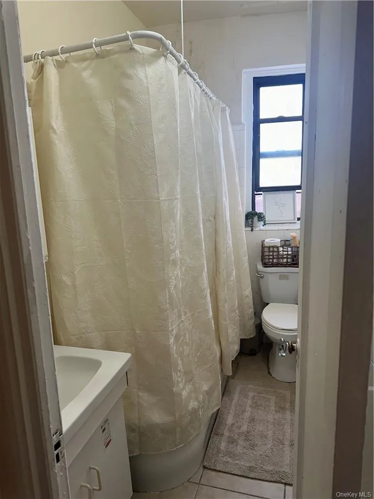 Bathroom featuring tile flooring, toilet, and vanity Bathroom featuring tile flooring, toilet, and vanity