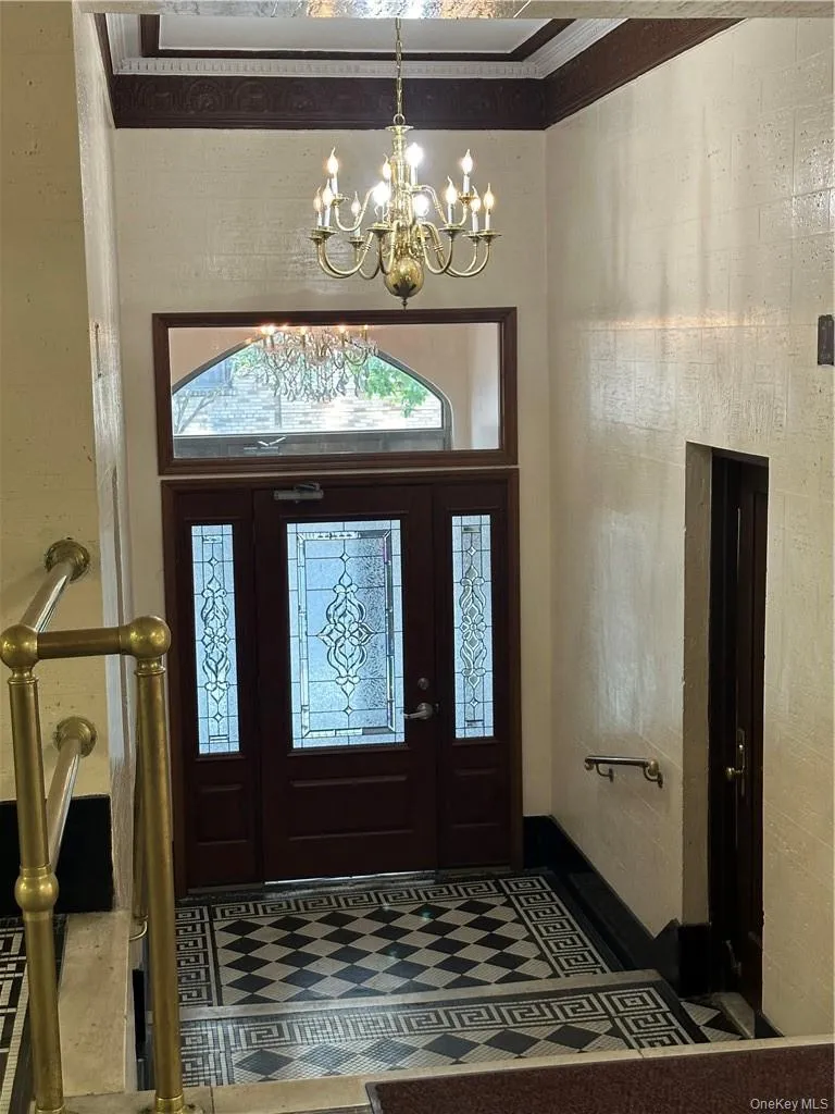 Tiled entryway with a chandelier and ornamental molding Tiled entryway with a chandelier and ornamental molding