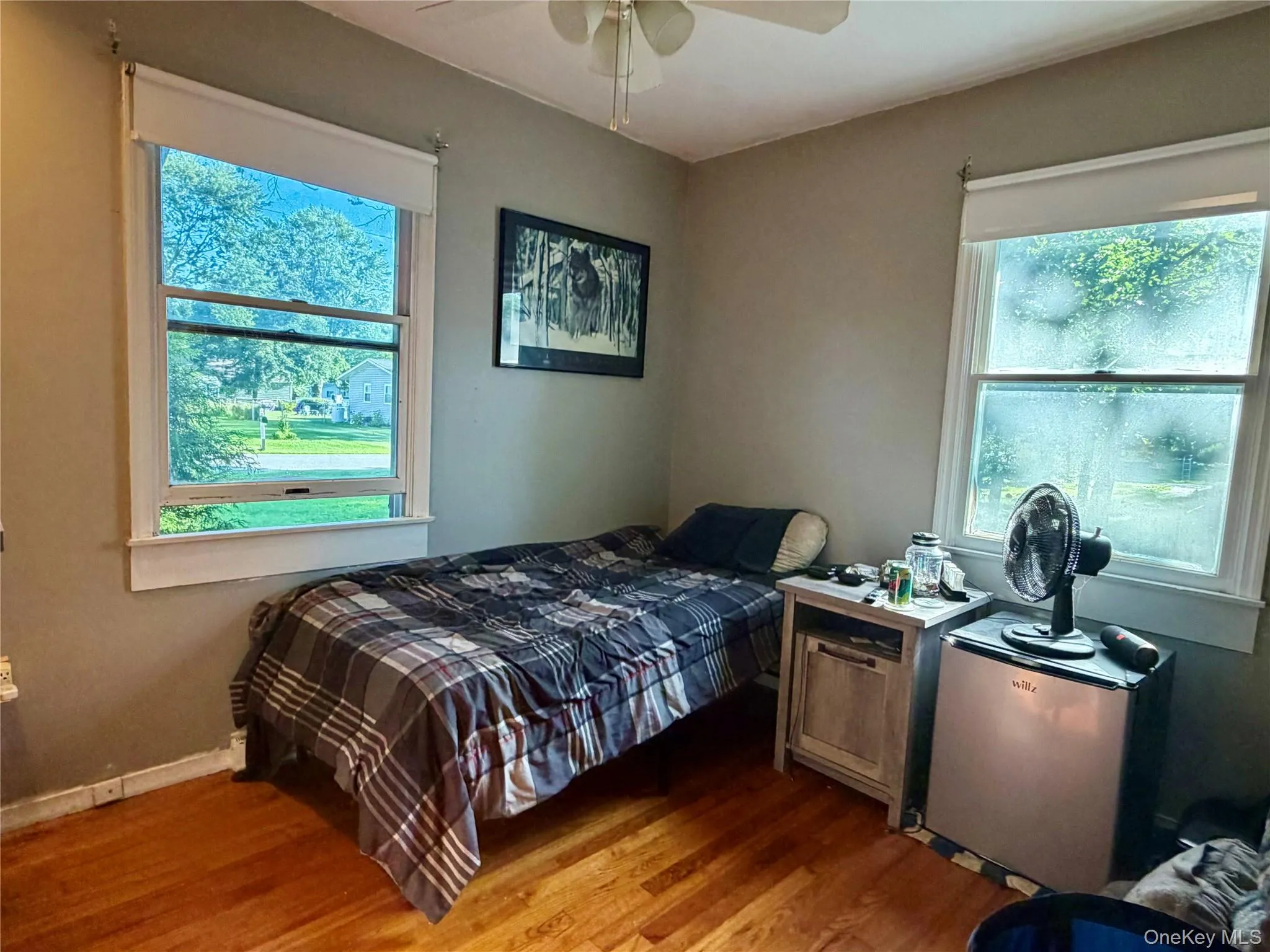 Wood-finish flooring with multiple windows and a ceiling fan Wood-finish flooring with multiple windows and a ceiling fan