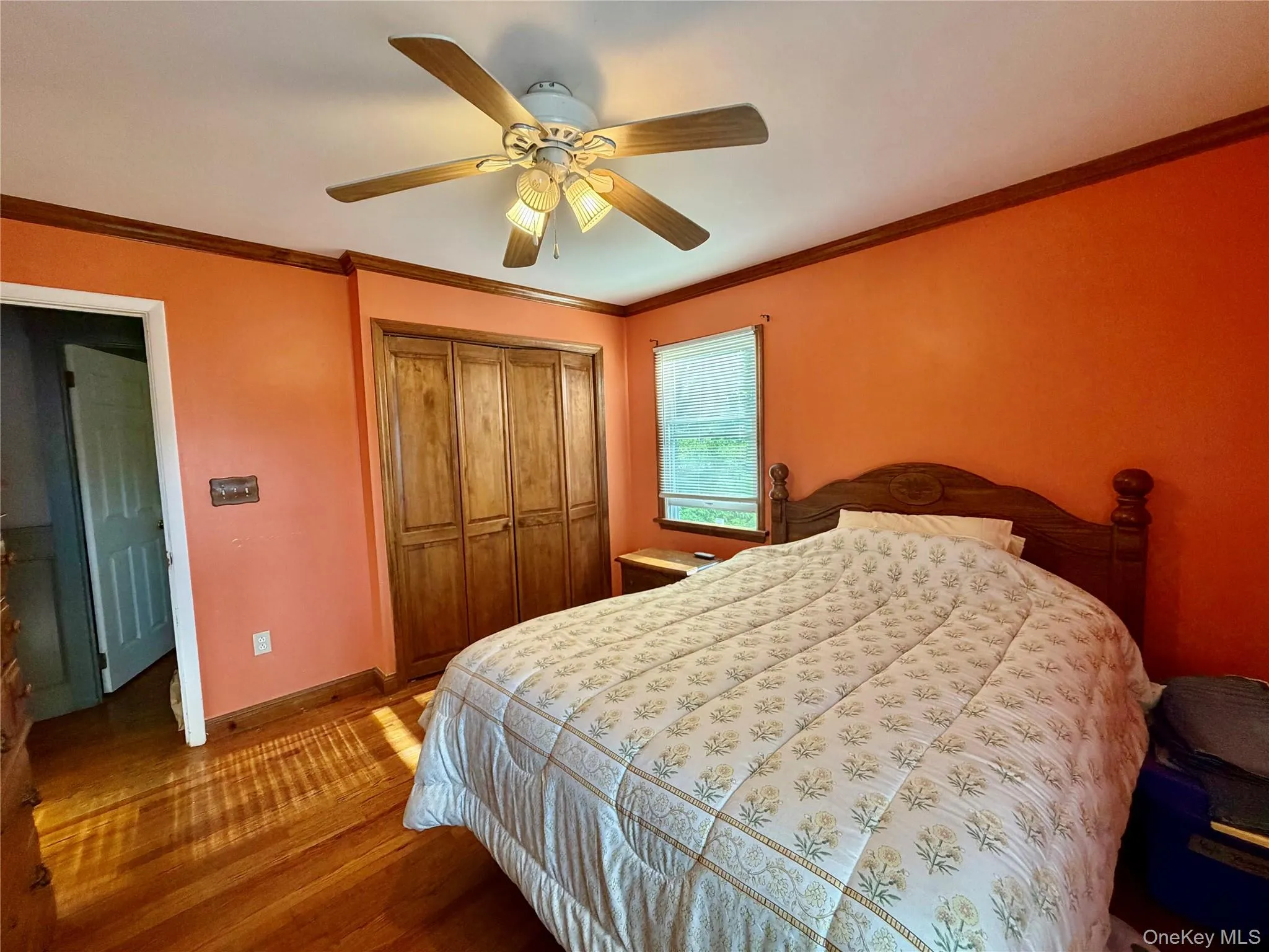 Wood-finish flooring, ceiling fan with integrated lighting, wood-finish bi-fold closet doors, and wood trim detailing Wood-finish flooring, ceiling fan with integrated lighting, wood-finish bi-fold closet doors, and wood trim detailing