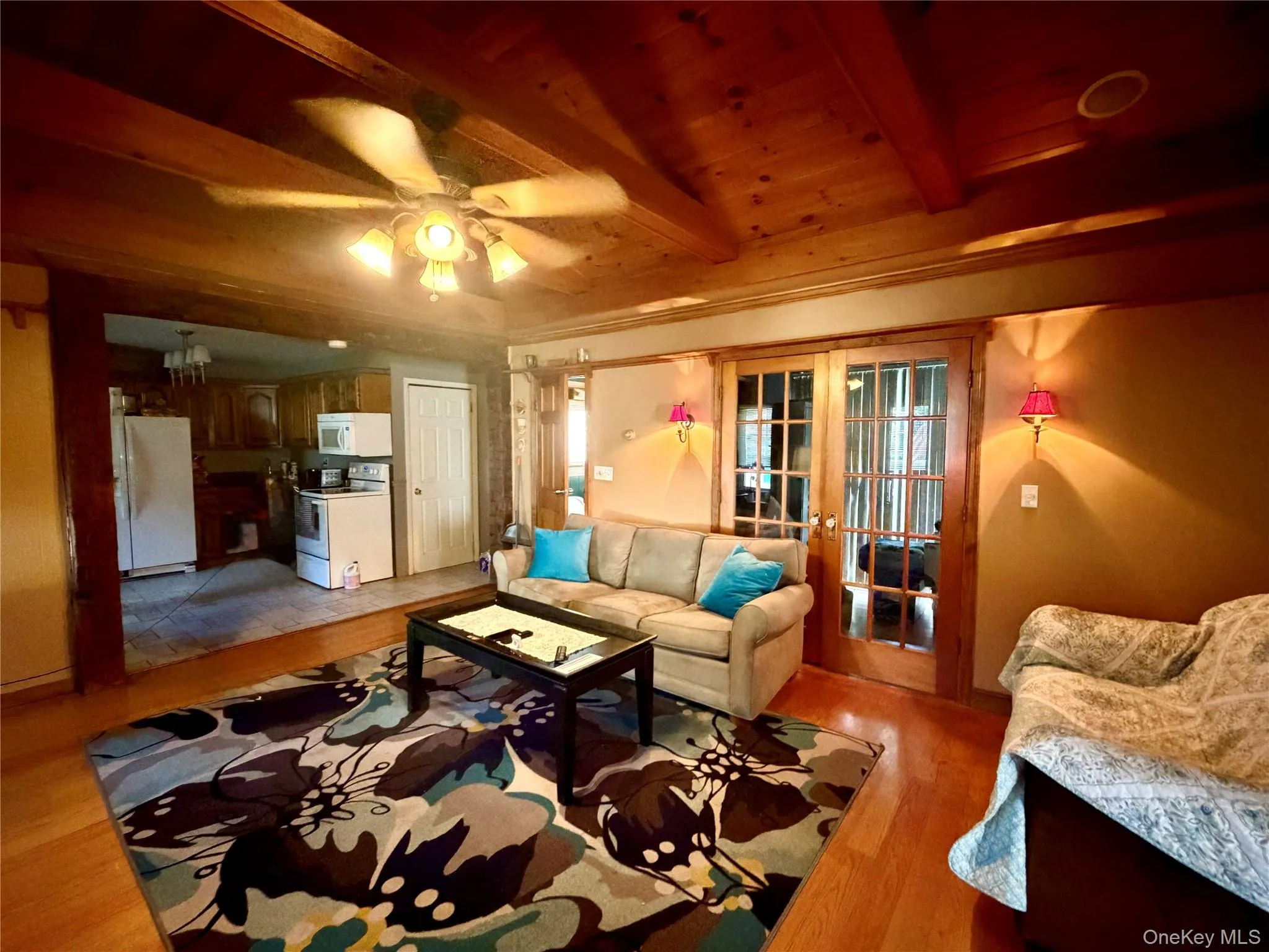 Wood-finish ceiling with exposed beams, wood-finish flooring, and French pane doors Wood-finish ceiling with exposed beams, wood-finish flooring, and French pane doors