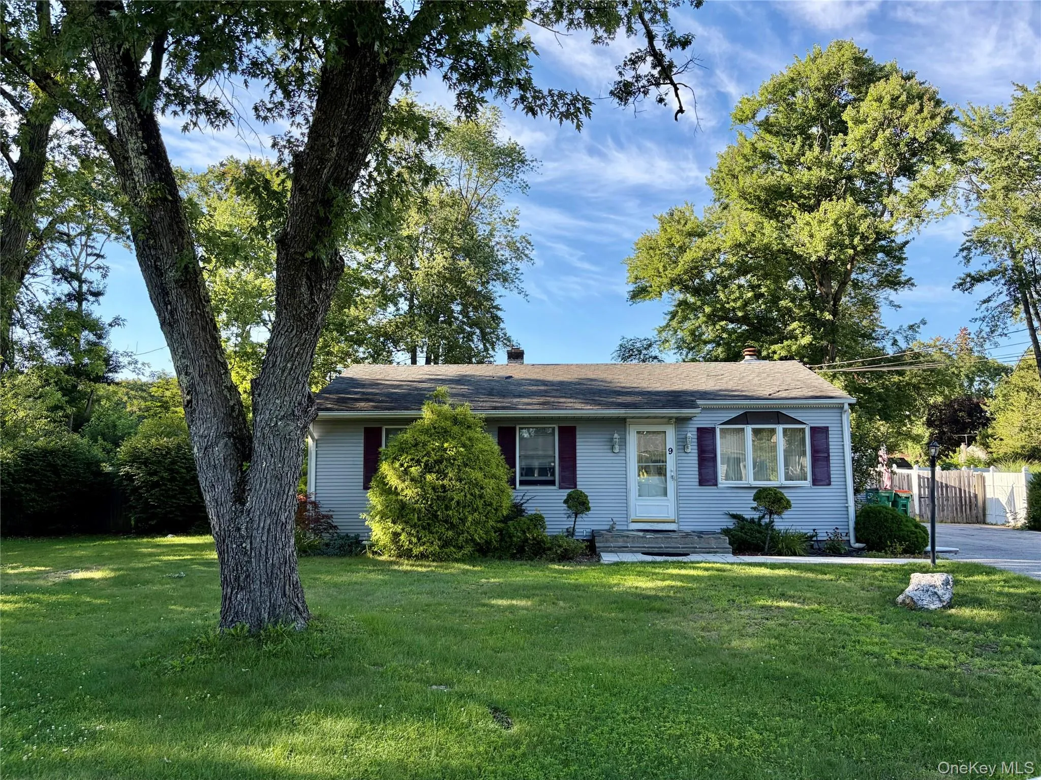 Light blue siding exterior with shutters, a bay window, and a white entry door Light blue siding exterior with shutters, a bay window, and a white entry door
