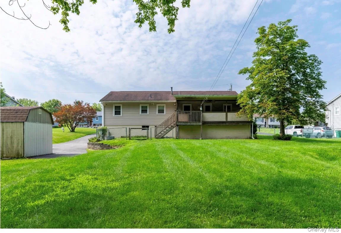 Rear exterior featuring siding, a second-story covered deck, exterior stairs, and a mature lands Rear exterior featuring siding, a second-story covered deck, exterior stairs, and a mature lands