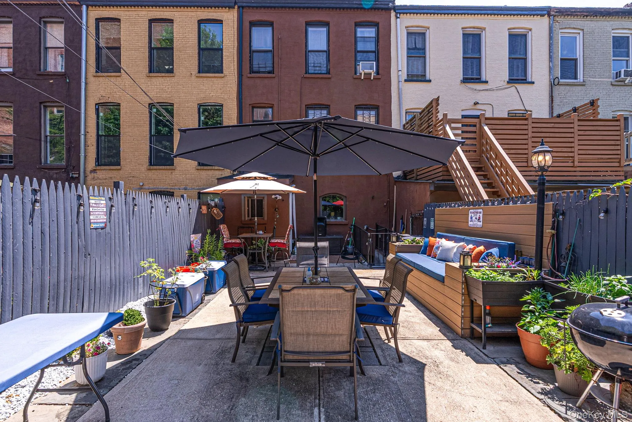 Paved patio with built-in seating, privacy fencing, and exterior lighting Paved patio with built-in seating, privacy fencing, and exterior lighting