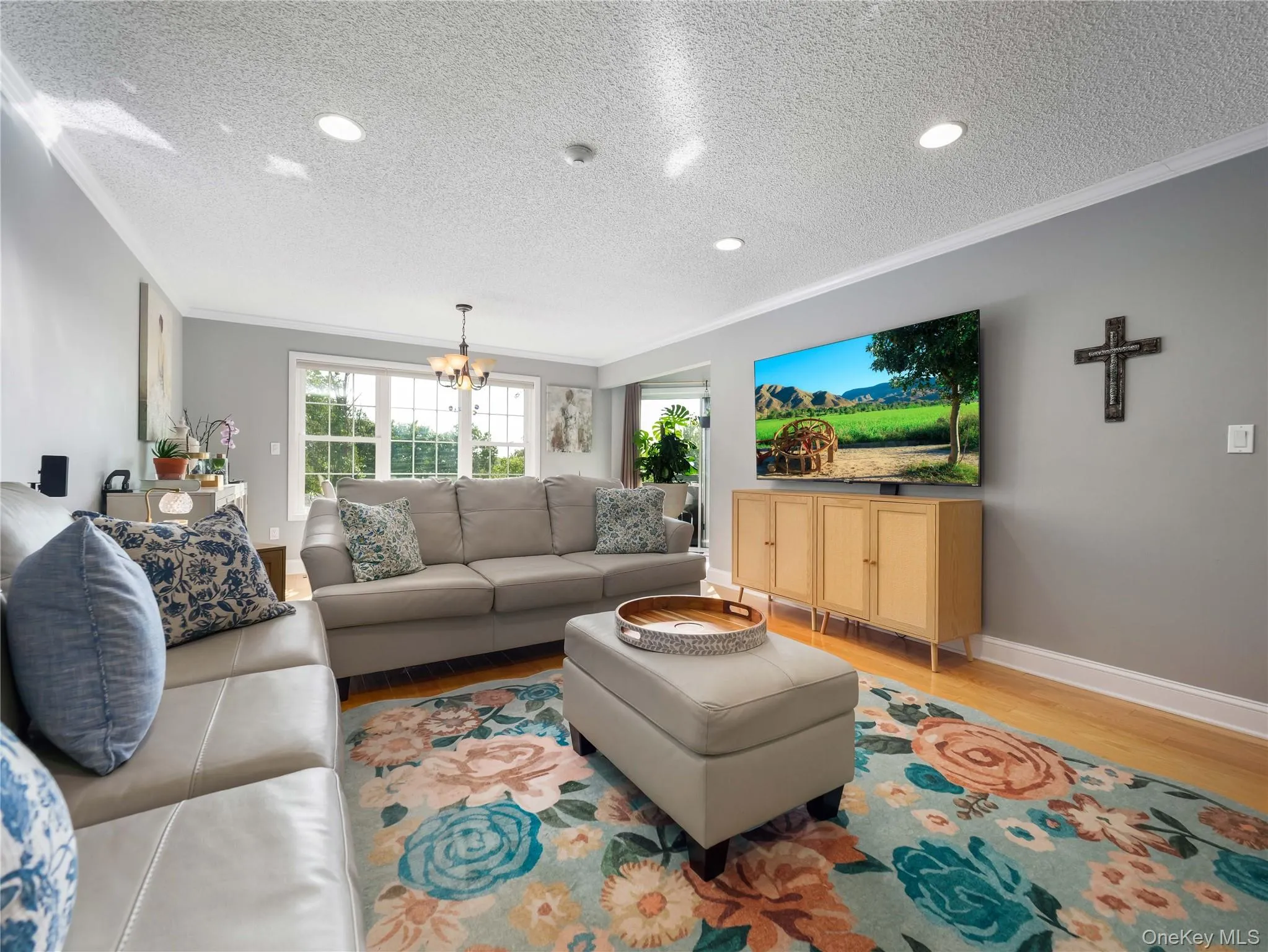 Living area featuring recessed lighting, multi-pane windows, and wood-finish flooring Living area featuring recessed lighting, multi-pane windows, and wood-finish flooring