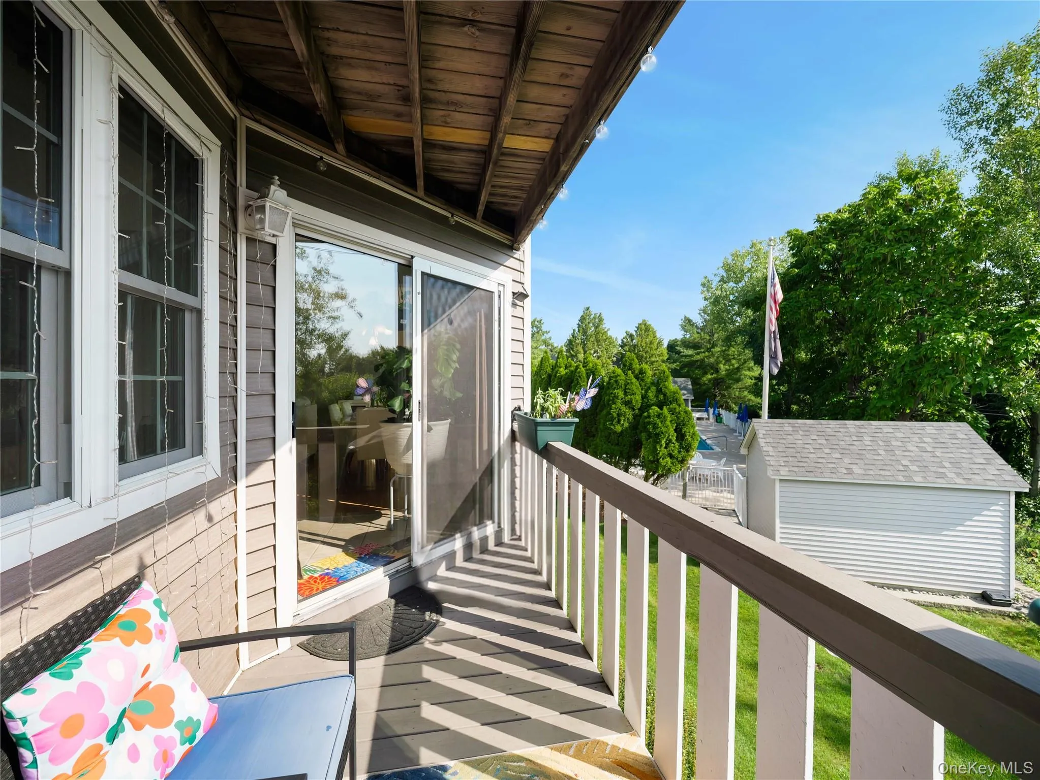 Covered balcony featuring horizontal siding, sliding glass doors, wooden decking, and a painted wood railing Covered balcony featuring horizontal siding, sliding glass doors, wooden decking, and a painted wood railing