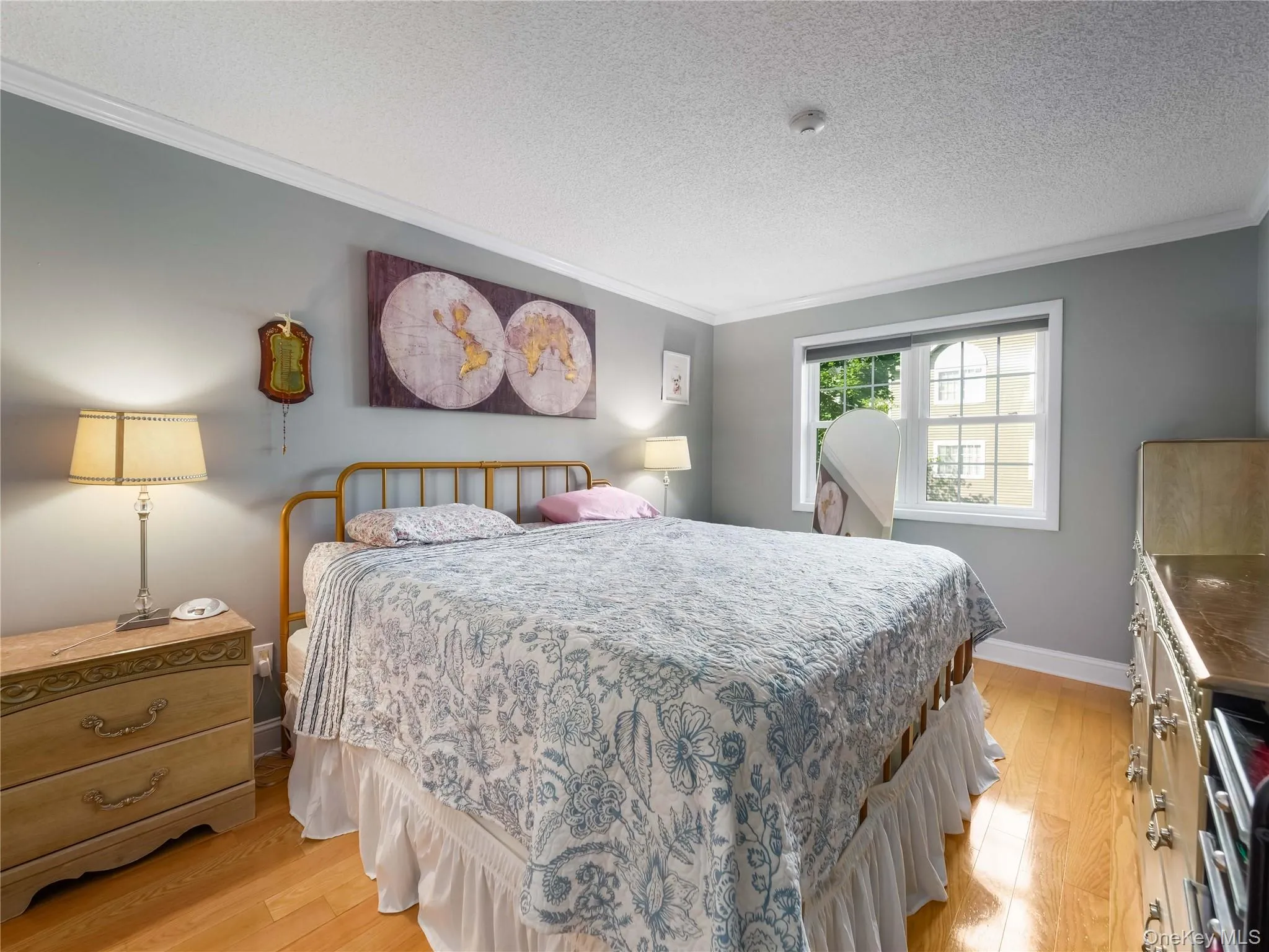 Interior room featuring wood-finish flooring, crown molding, and a multi-pane window with white trim Interior room featuring wood-finish flooring, crown molding, and a multi-pane window with white trim