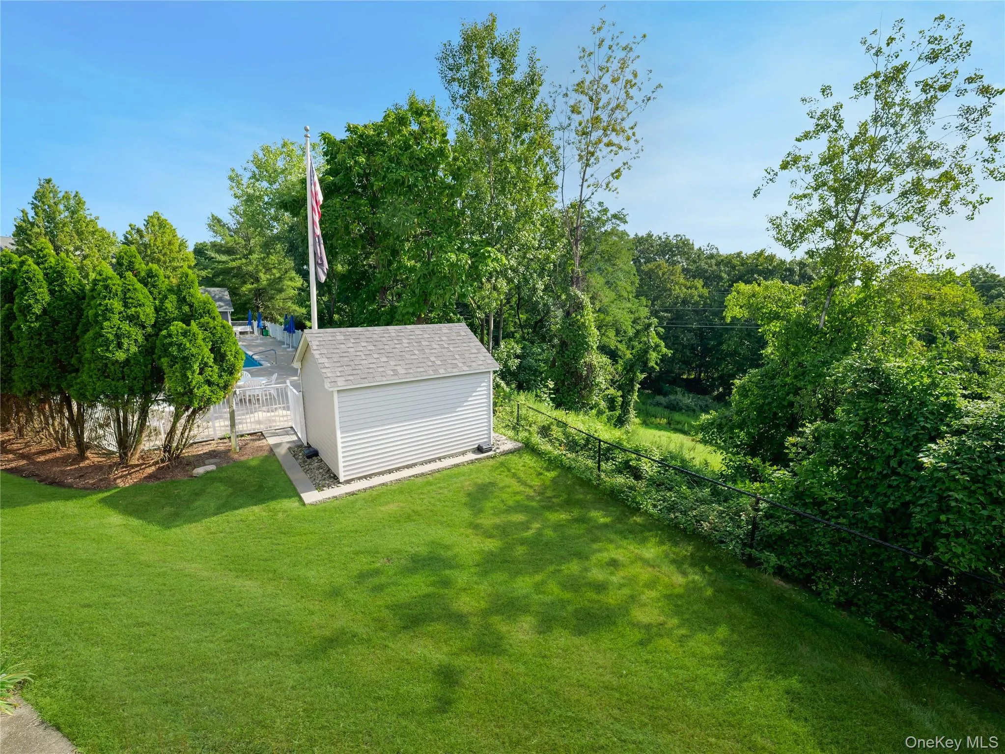 Spacious backyard featuring a manicured lawn, detached storage shed, perimeter fencing, and mature tree landscaping Spacious backyard featuring a manicured lawn, detached storage shed, perimeter fencing, and mature tree landscaping