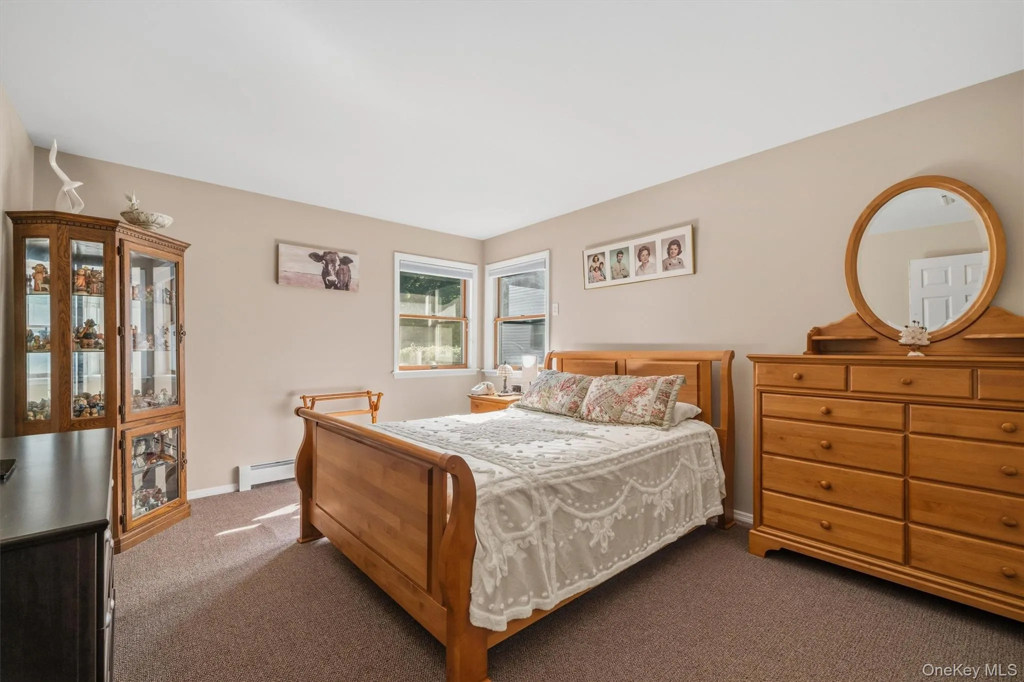Mother/daughter Corner windows with white trim, tan wall paint, brown carpet flooring, and a ceiling light fixture Mother/daughter Corner windows with white trim, tan wall paint, brown carpet flooring, and a ceiling light fixture