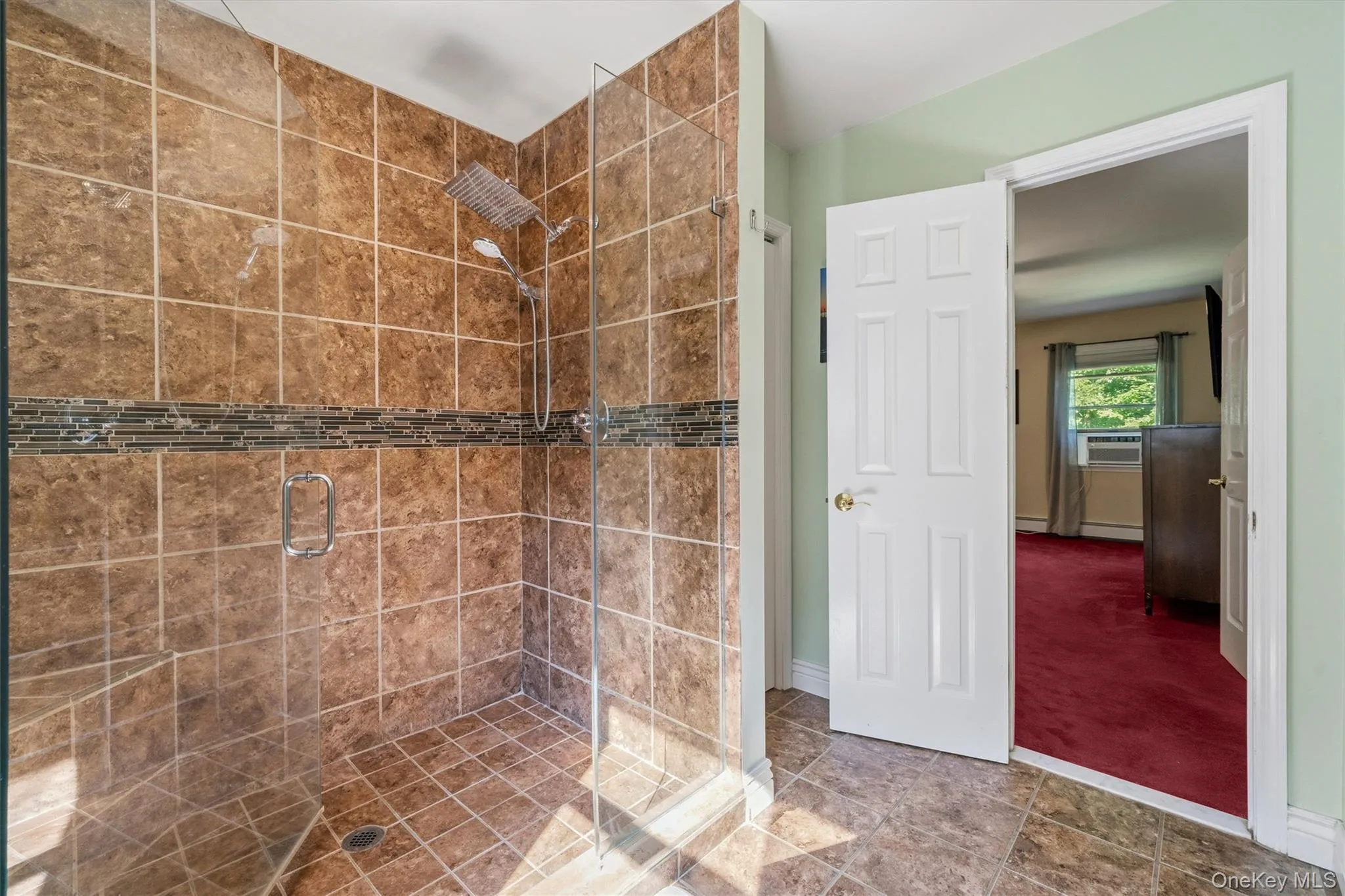 Glass-enclosed shower with full-height tile surround, mosaic accent band, and a multi-function shower head Glass-enclosed shower with full-height tile surround, mosaic accent band, and a multi-function shower head