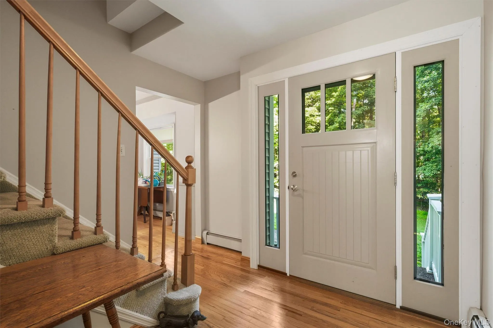 Hardwood flooring, paneled entry door with transom window, and flanking sidelight windows Hardwood flooring, paneled entry door with transom window, and flanking sidelight windows