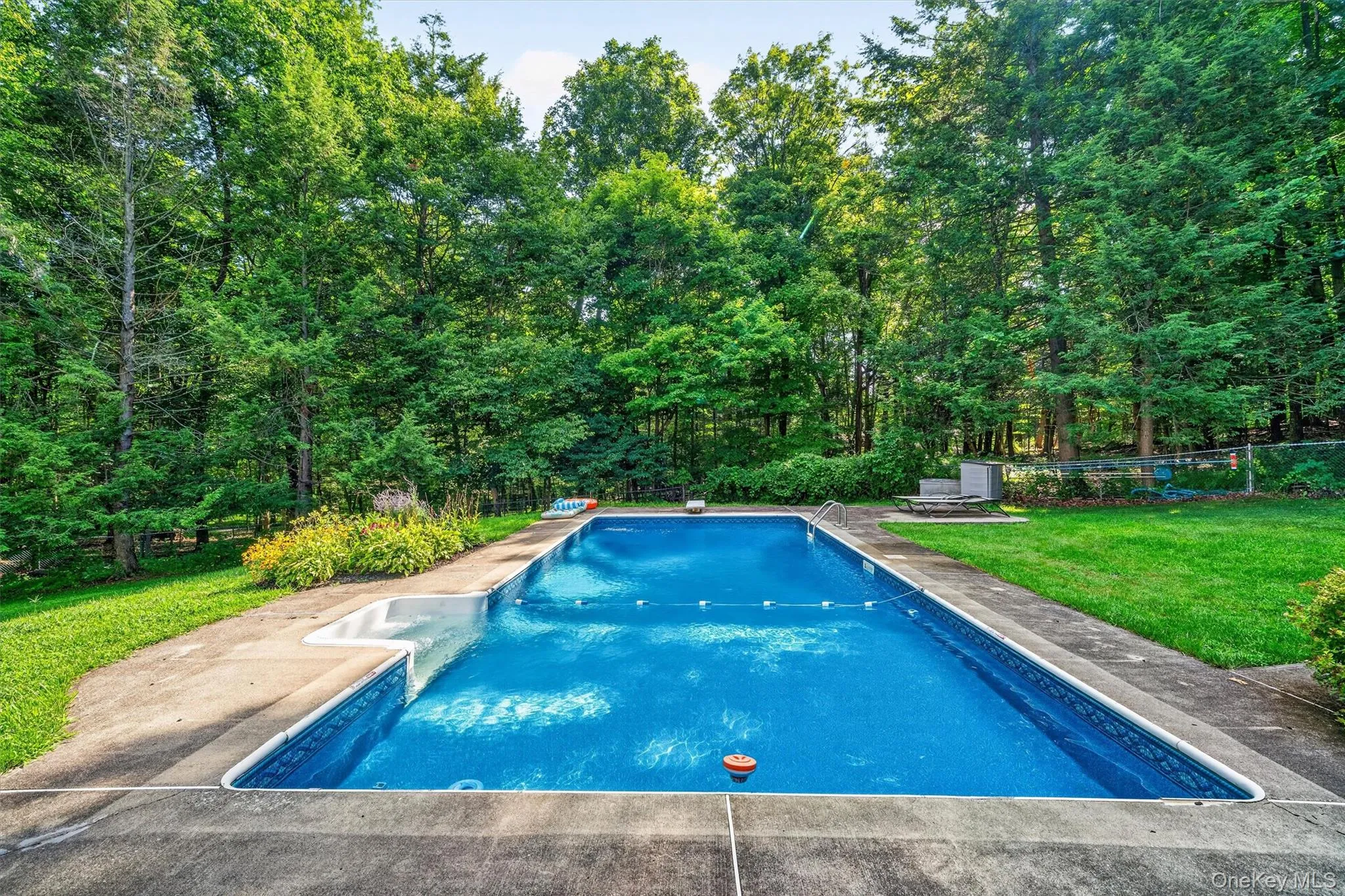 Large in-ground swimming pool with concrete surround Large in-ground swimming pool with concrete surround