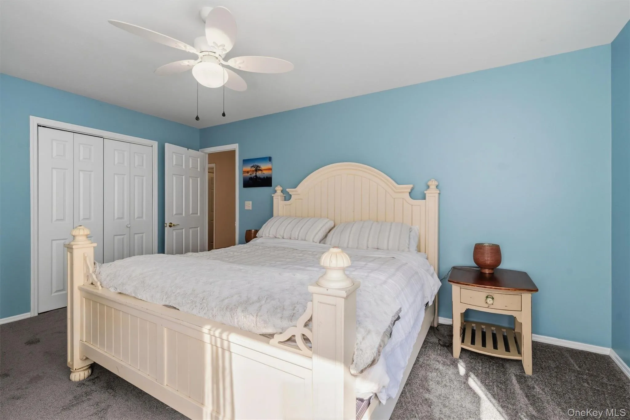 Ceiling fan with integrated lighting, bi-fold closet doors, and light blue wall paint Ceiling fan with integrated lighting, bi-fold closet doors, and light blue wall paint