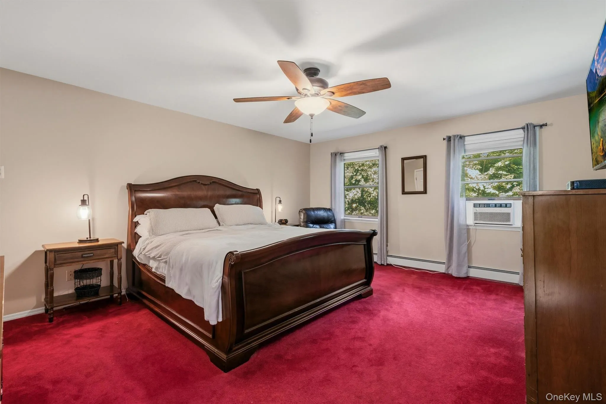 Ceiling fan with integrated lighting, multiple windows, wood-finish flooring, and neutral wall tones Ceiling fan with integrated lighting, multiple windows, wood-finish flooring, and neutral wall tones