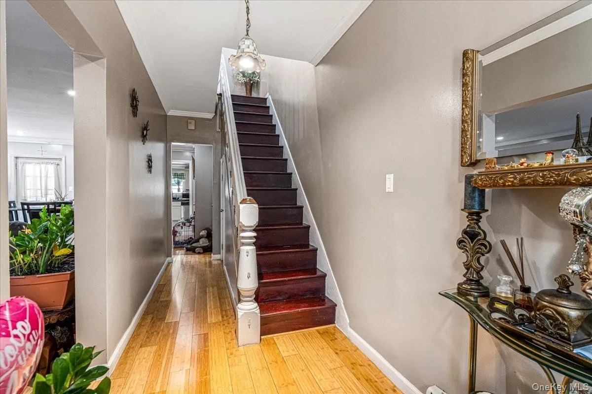 A striking dark wood staircase stands out as a beautiful centerpiece, perfectly complementing the bright hardwood floors. The long hallway draws you further into the home while offering a spacious, open feel right from the entrance. A striking dark wood staircase stands out as a beautiful centerpiece, perfectly complementing the bright hardwood floors. The long hallway draws you further into the home while offering a spacious, open feel right from the entrance.