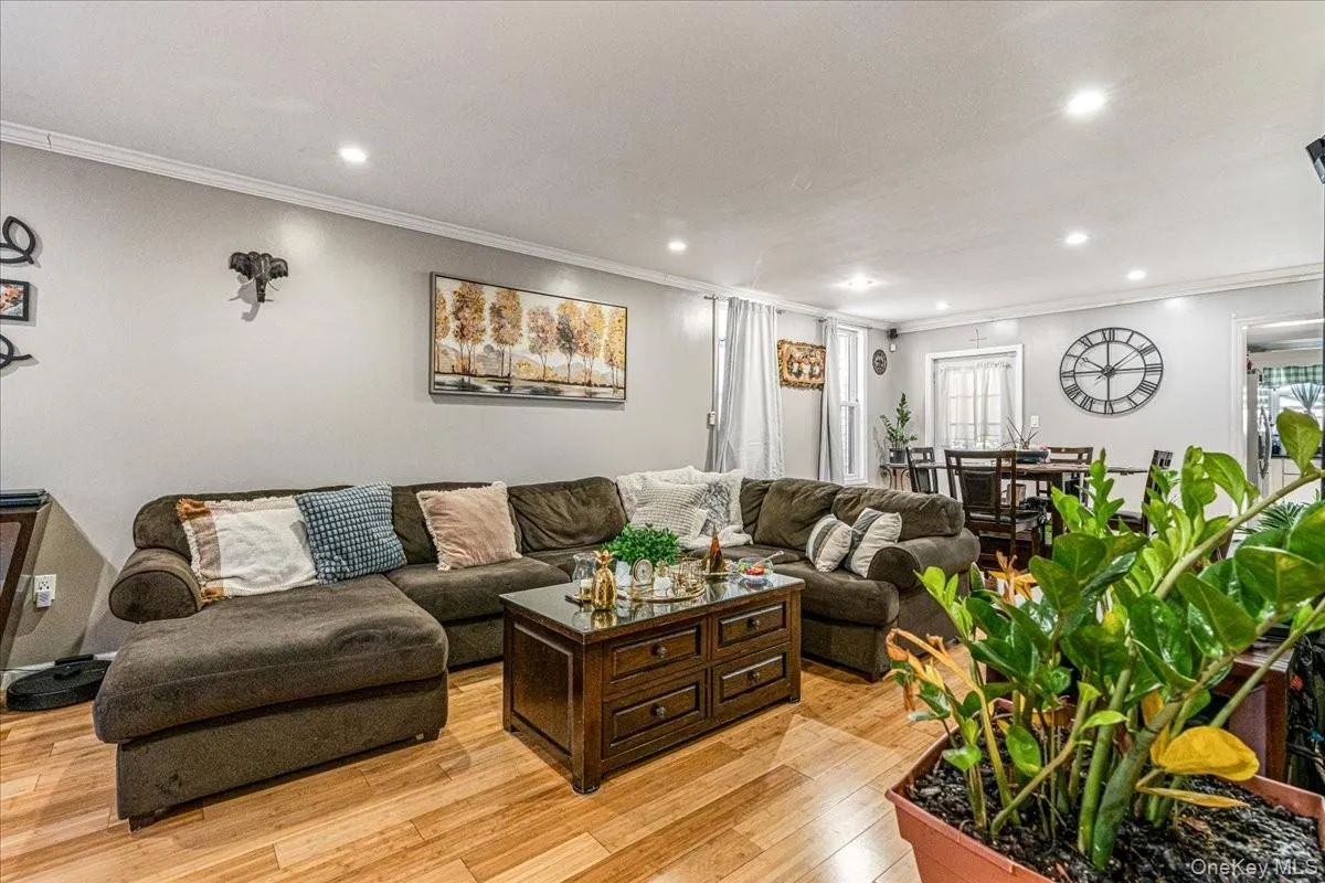 This spacious living room features bright hardwood floors and a massive open layout that flows seamlessly into the dining area. Recessed ceiling lighting and neutral walls create a warm, inviting atmosphere with plenty of space for large sectional seating. This spacious living room features bright hardwood floors and a massive open layout that flows seamlessly into the dining area. Recessed ceiling lighting and neutral walls create a warm, inviting atmosphere with plenty of space for large sectional seating.