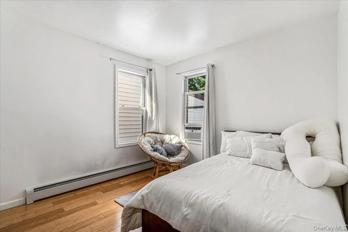 This bright bedroom features beautiful hardwood floors, clean white walls, and two corner windows that let in plenty of natural light. The comfortable layout leaves plenty of space for a large bed and extra furniture. This bright bedroom features beautiful hardwood floors, clean white walls, and two corner windows that let in plenty of natural light. The comfortable layout leaves plenty of space for a large bed and extra furniture.