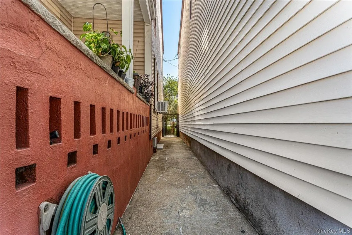 A concrete side alley connects the front of the property directly to the backyard for easy outdoor access. This straight, paved walkway is bordered by a solid brick feature wall, keeping the side of the home organized and highly accessible. A concrete side alley connects the front of the property directly to the backyard for easy outdoor access. This straight, paved walkway is bordered by a solid brick feature wall, keeping the side of the home organized and highly accessible.