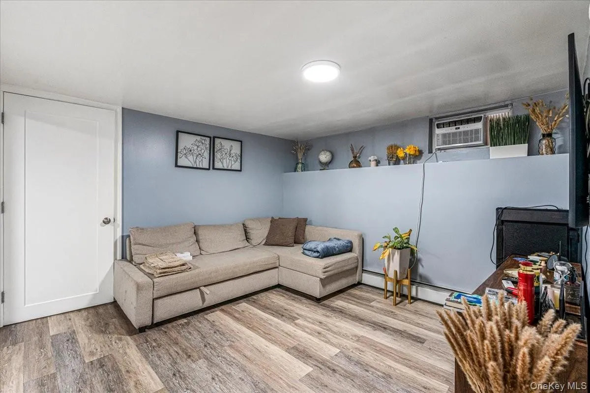 This spacious basement living room features beautiful wood-look flooring, cool blue walls, and a comfortable layout. It is a highly versatile space that is perfect for a cozy family media room, playroom, or guest lounge. This spacious basement living room features beautiful wood-look flooring, cool blue walls, and a comfortable layout. It is a highly versatile space that is perfect for a cozy family media room, playroom, or guest lounge.