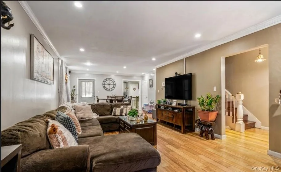 Recessed lighting, crown molding, wood-finish flooring, and a built-in entertainment console Recessed lighting, crown molding, wood-finish flooring, and a built-in entertainment console