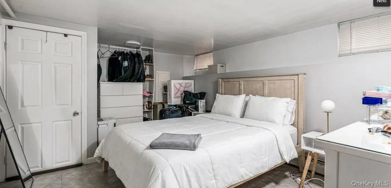This bright bedroom features a large, comfortable layout that easily fits a full-sized bed and multiple dressers. With an open closet system and clean white walls, it provides a quiet and highly functional private space for guests or an in-law suite. This bright bedroom features a large, comfortable layout that easily fits a full-sized bed and multiple dressers. With an open closet system and clean white walls, it provides a quiet and highly functional private space for guests or an in-law suite.