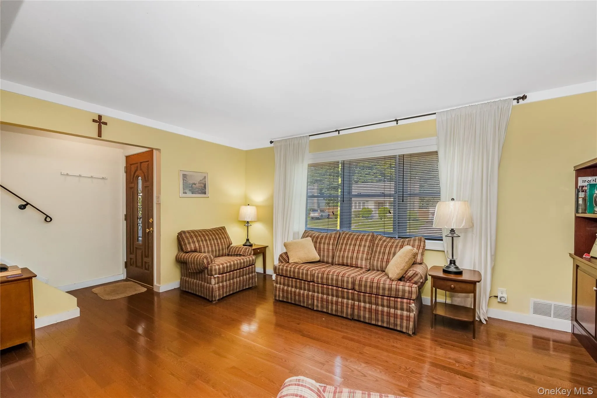 Hardwood flooring throughout, a decorative front entry door, and a large front-facing window Hardwood flooring throughout, a decorative front entry door, and a large front-facing window