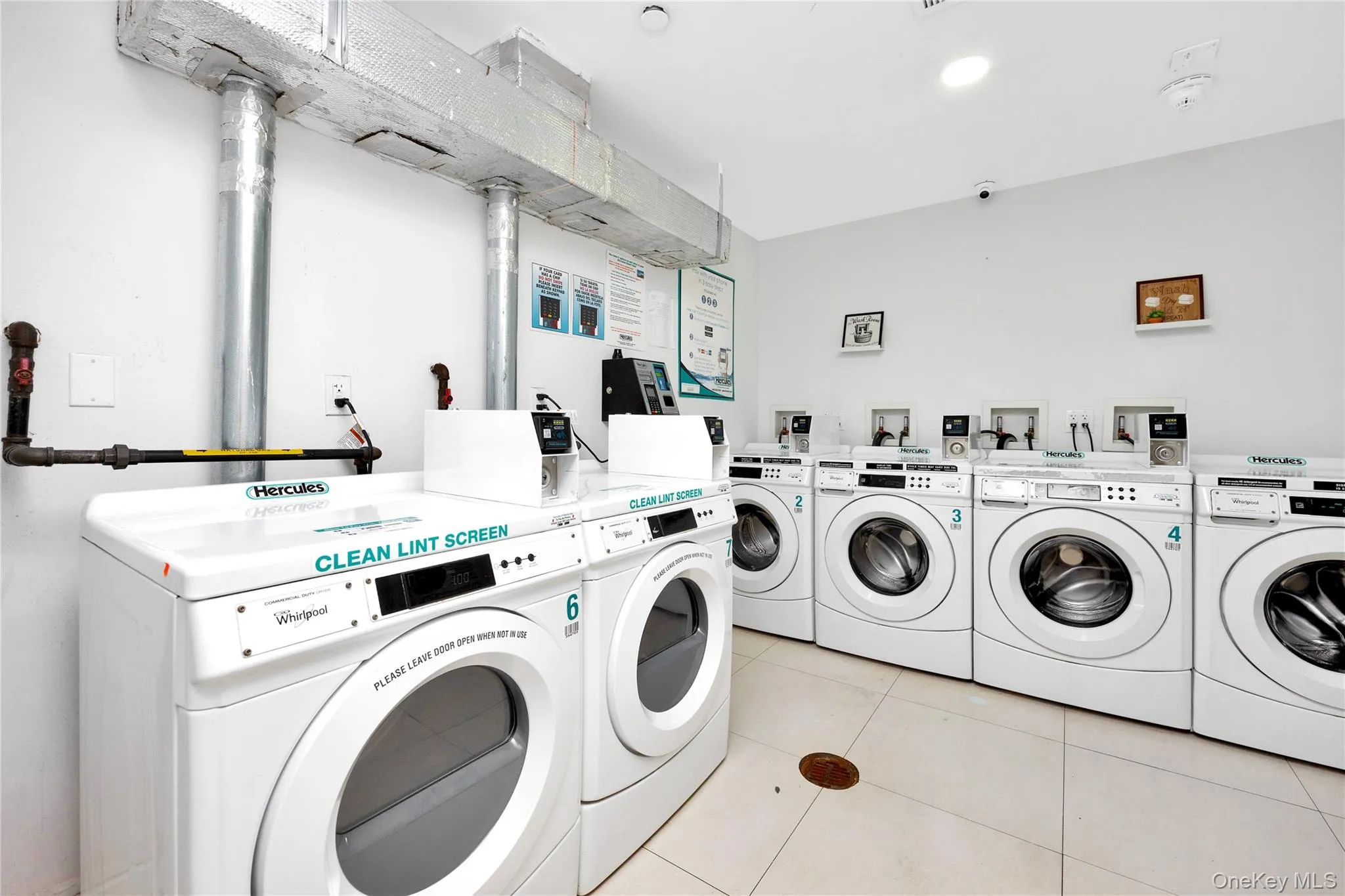 Community laundry room featuring light tile patterned floors and washer and clothes dryer Community laundry room featuring light tile patterned floors and washer and clothes dryer