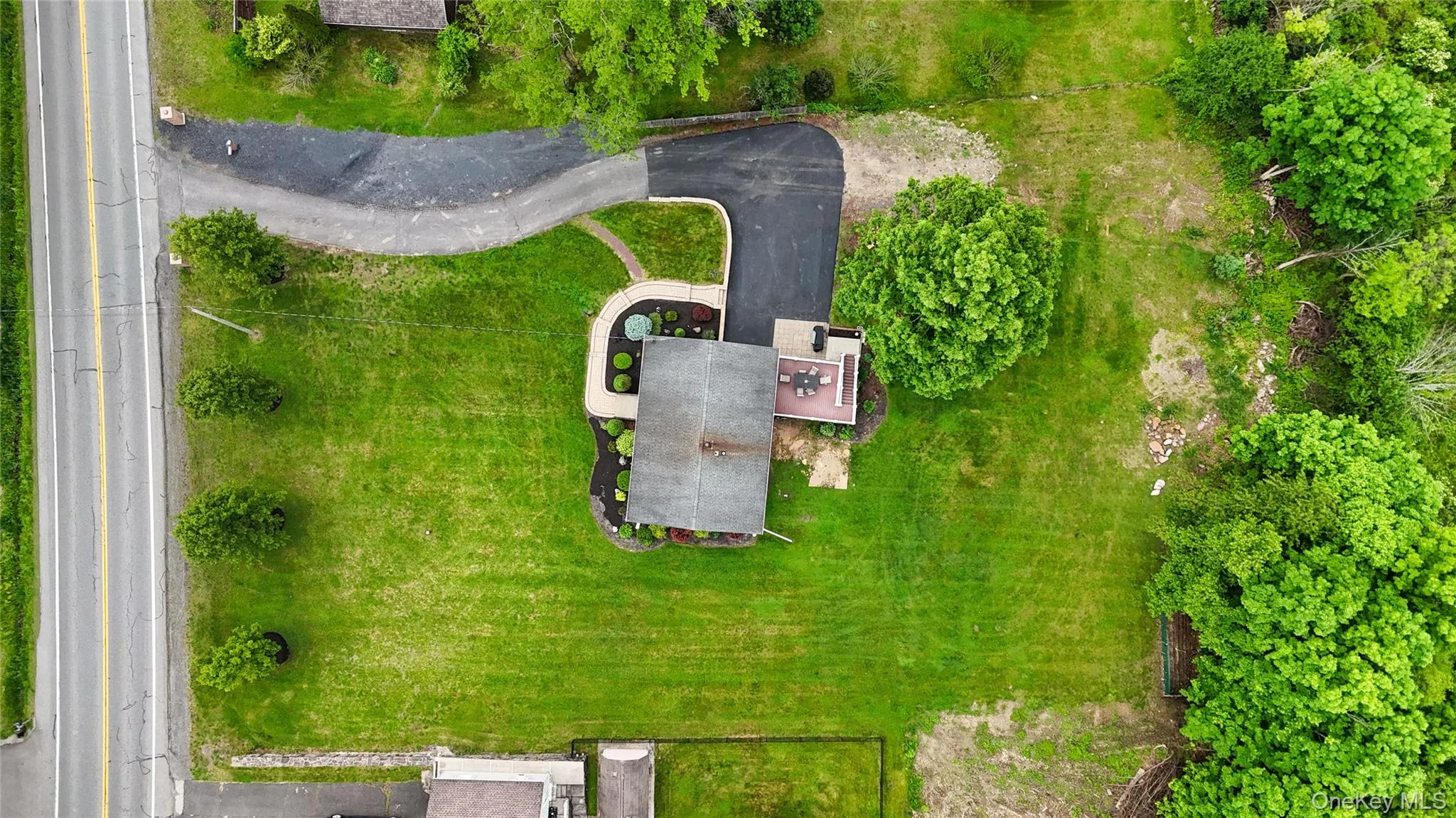 Aerial view of a contemporary residence set on expansive manicured grounds with mature landscaping Aerial view of a contemporary residence set on expansive manicured grounds with mature landscaping