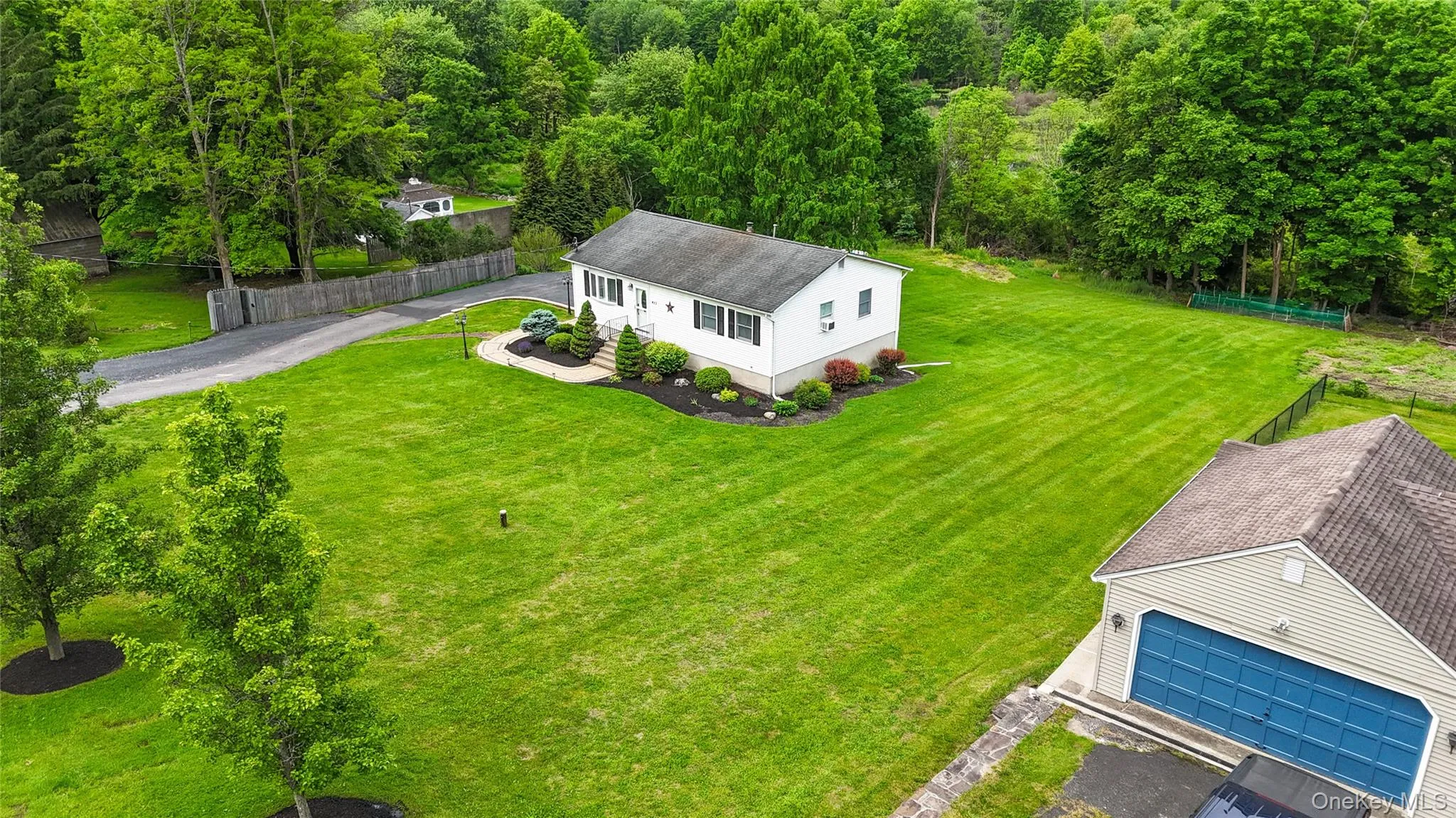 Expansive, well-maintained lawn with mature trees and professional landscaping Expansive, well-maintained lawn with mature trees and professional landscaping
