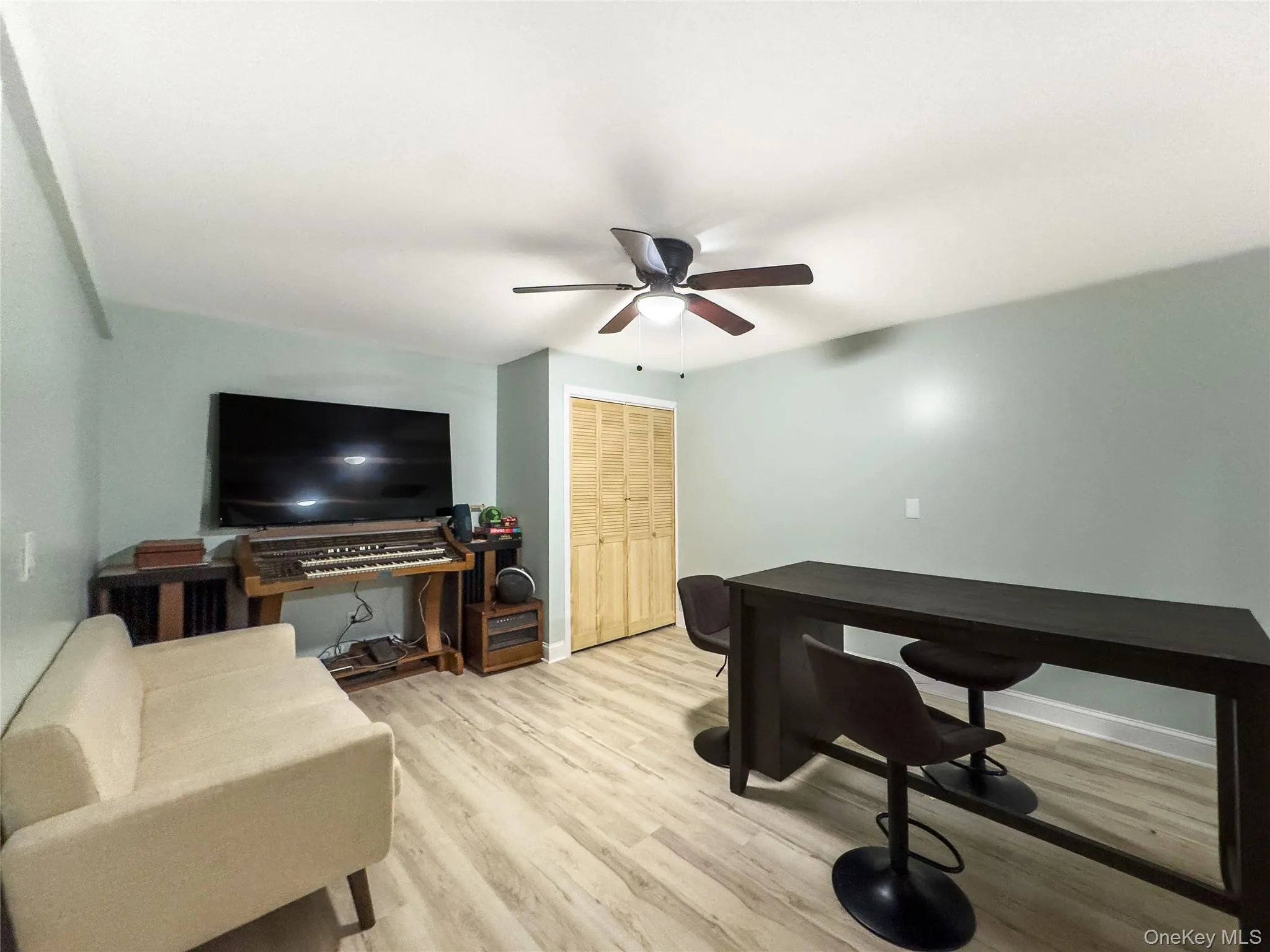 Versatile multi-use room featuring wood-finish flooring, ceiling fan with integrated lighting, and ample natural light from recessed fixtures Versatile multi-use room featuring wood-finish flooring, ceiling fan with integrated lighting, and ample natural light from recessed fixtures