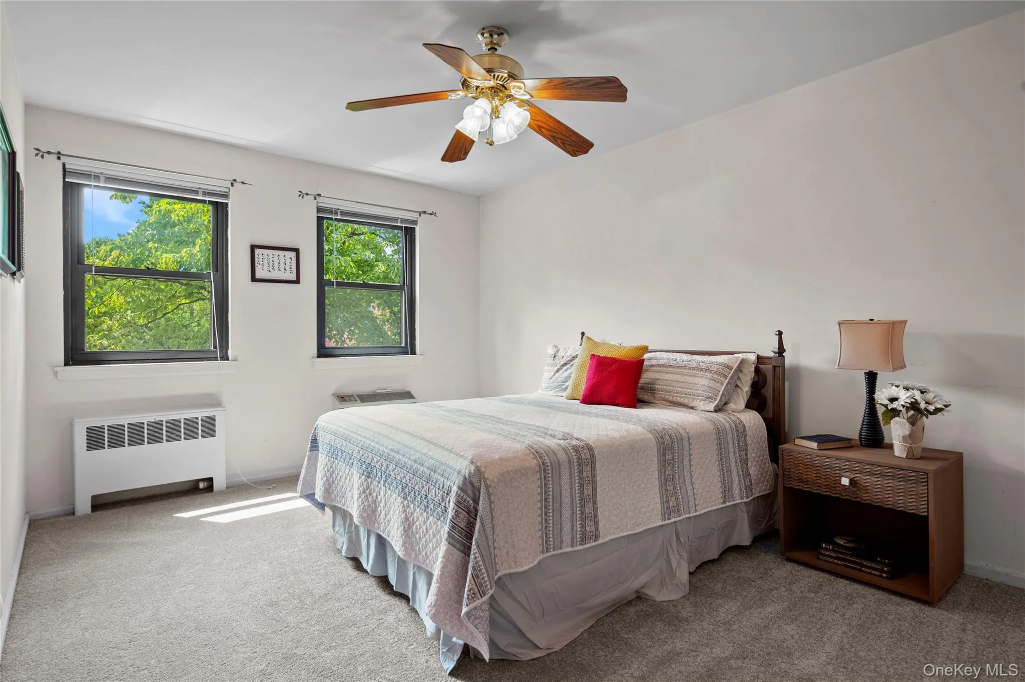 Primary bedroom with wall-to-wall carpeting with light-toned walls, ceiling fan with integrated lighting, and dual windows Primary bedroom with wall-to-wall carpeting with light-toned walls, ceiling fan with integrated lighting, and dual windows