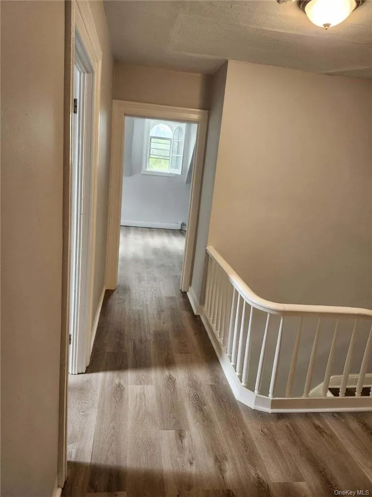 Hallway featuring a textured ceiling and updated contemporary flooring Hallway featuring a textured ceiling and updated contemporary flooring