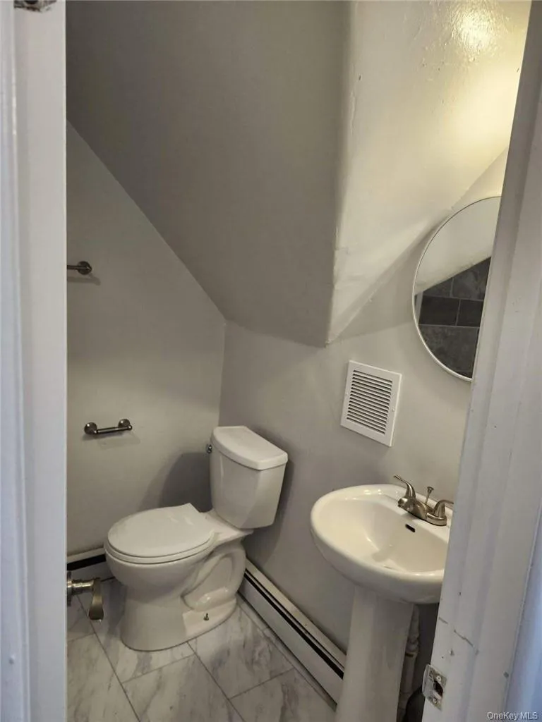 Bathroom with tile patterned floors, baseboard heating, and toilet Bathroom with tile patterned floors, baseboard heating, and toilet