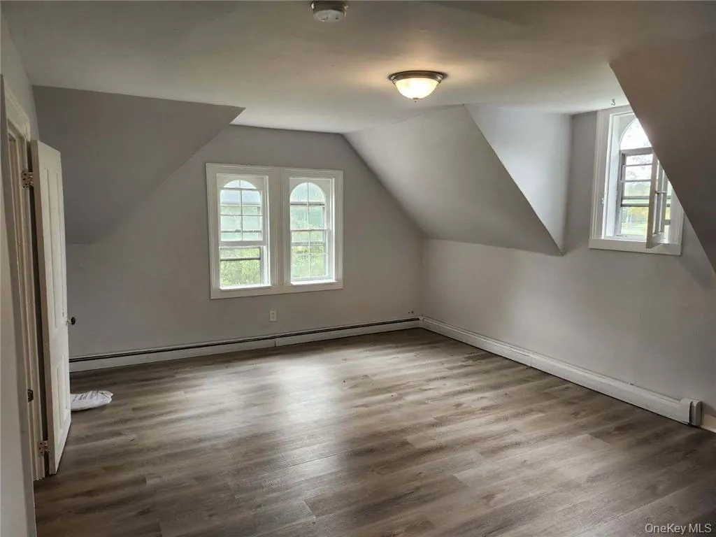 Living room/Bedroom room with a baseboard heating unit, vaulted ceiling, and a wealth of natural light Living room/Bedroom room with a baseboard heating unit, vaulted ceiling, and a wealth of natural light