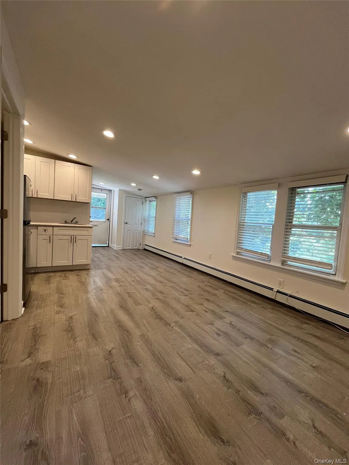 Wood-finish flooring throughout, recessed lighting, and multiple windows with blinds Wood-finish flooring throughout, recessed lighting, and multiple windows with blinds