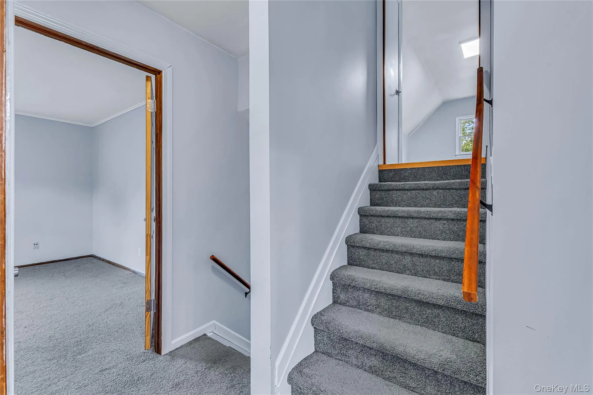 Staircase with wood-finish railing and carpeted treads Staircase with wood-finish railing and carpeted treads