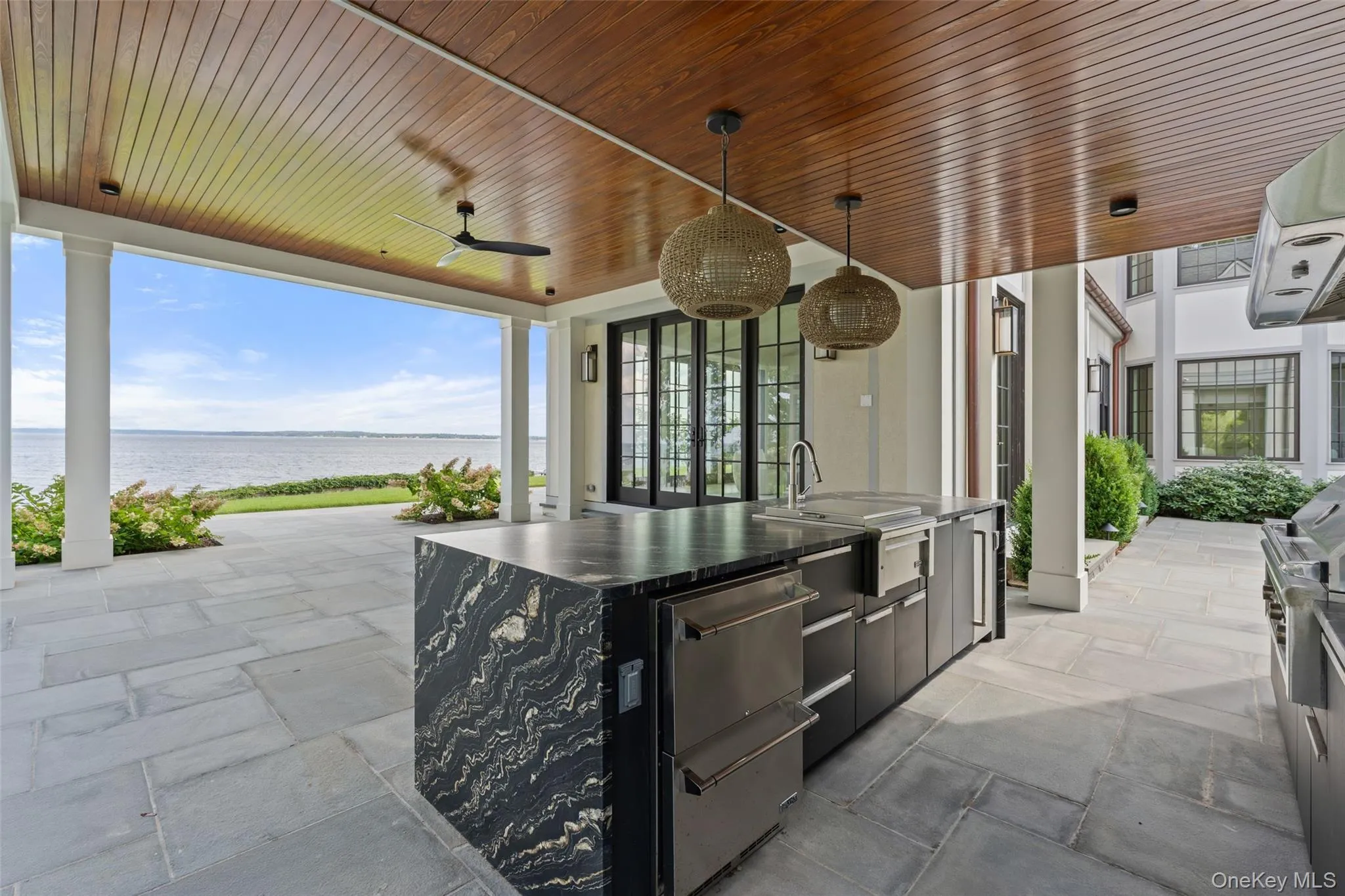 Fully equipped outdoor kitchen designed for poolside dining with sweeping water views. Fully equipped outdoor kitchen designed for poolside dining with sweeping water views.