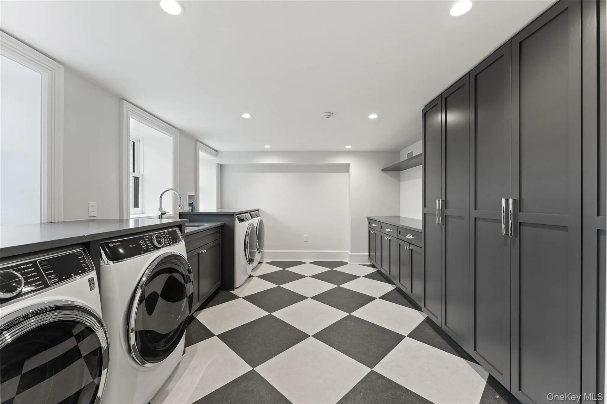 Exceptional second laundry room with dual washer/dryer sets, sink and abundant custom cabinetry. Exceptional second laundry room with dual washer/dryer sets, sink and abundant custom cabinetry.
