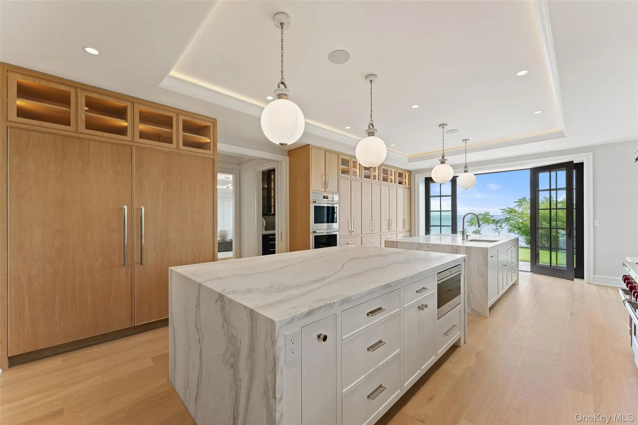 Chef’s kitchen with dramatic marble islands, white oak cabinetry, sweeping water views, and professional-grade cooking. Chef’s kitchen with dramatic marble islands, white oak cabinetry, sweeping water views, and professional-grade cooking.