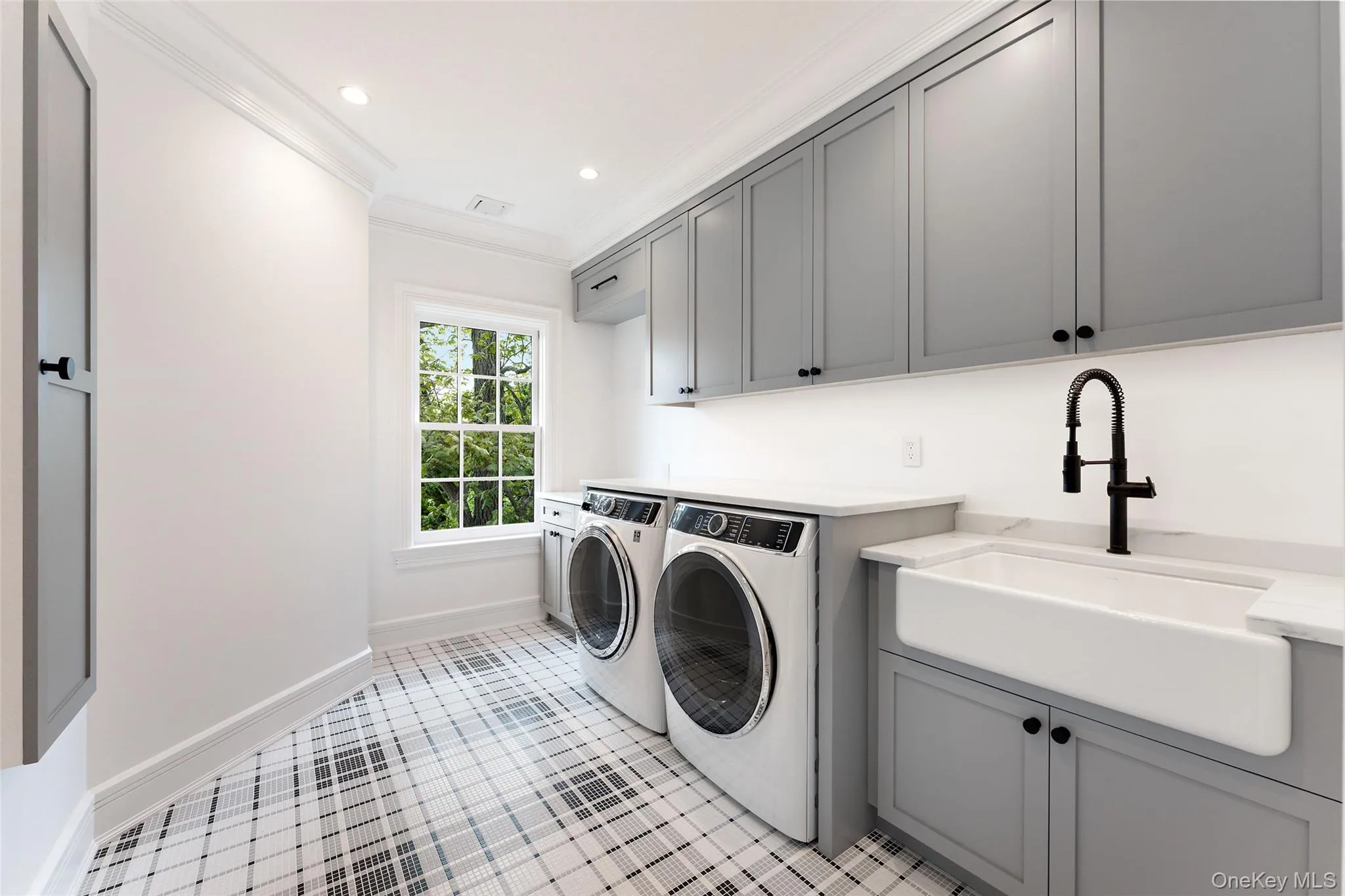 Well-appointed second-floor laundry with custom cabinetry, utility sink and generous workspace. Well-appointed second-floor laundry with custom cabinetry, utility sink and generous workspace.
