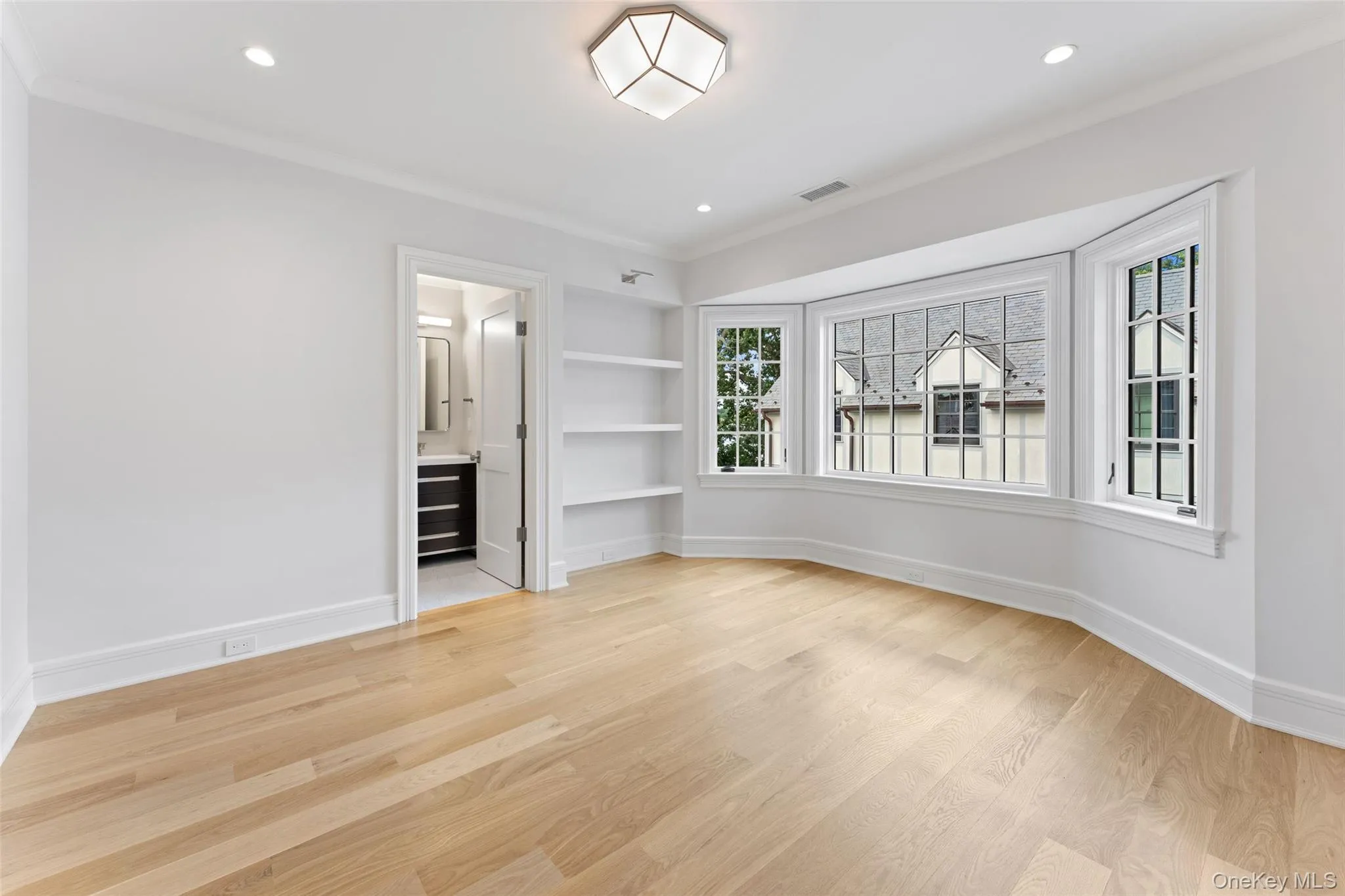 Bedroom with ensuite bathroom, bay windows, built-in shelving and white oak floors. Bedroom with ensuite bathroom, bay windows, built-in shelving and white oak floors.
