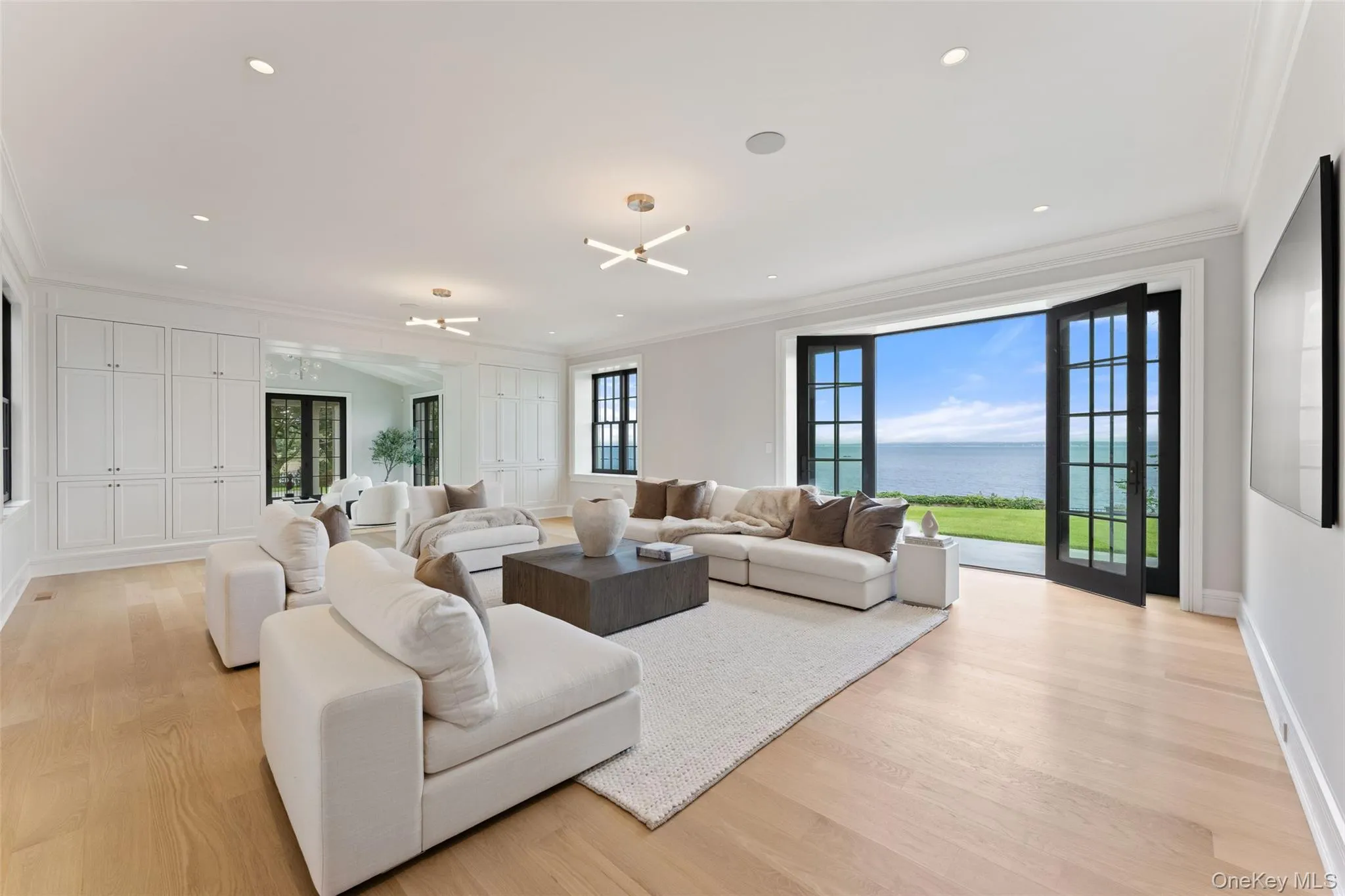 Light-filled family room with sweeping water views and direct terrace access. Light-filled family room with sweeping water views and direct terrace access.