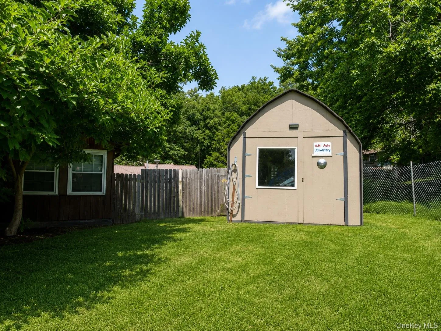 Spacious backyard retreat featuring a detached shed with peaked roof, single-pane window, and arched door accent Spacious backyard retreat featuring a detached shed with peaked roof, single-pane window, and arched door accent
