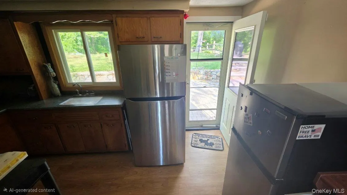 Wood-finish flooring, wood cabinetry, built-in sink, and stainless steel refrigerator Wood-finish flooring, wood cabinetry, built-in sink, and stainless steel refrigerator