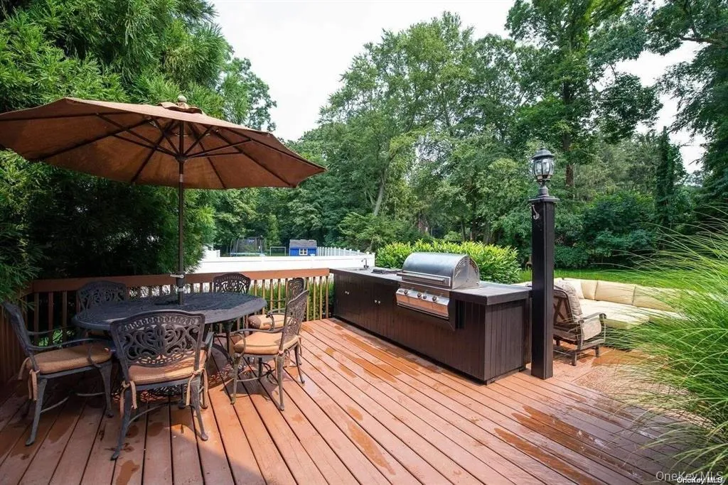 Wooden terrace featuring outdoor dining area and exterior kitchen Wooden terrace featuring outdoor dining area and exterior kitchen