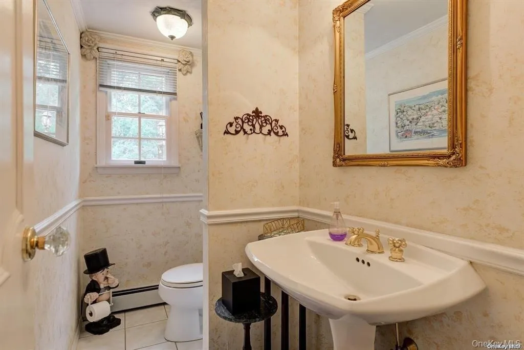Bathroom featuring crown molding, wallpapered walls, tile patterned flooring, and baseboard heating Bathroom featuring crown molding, wallpapered walls, tile patterned flooring, and baseboard heating