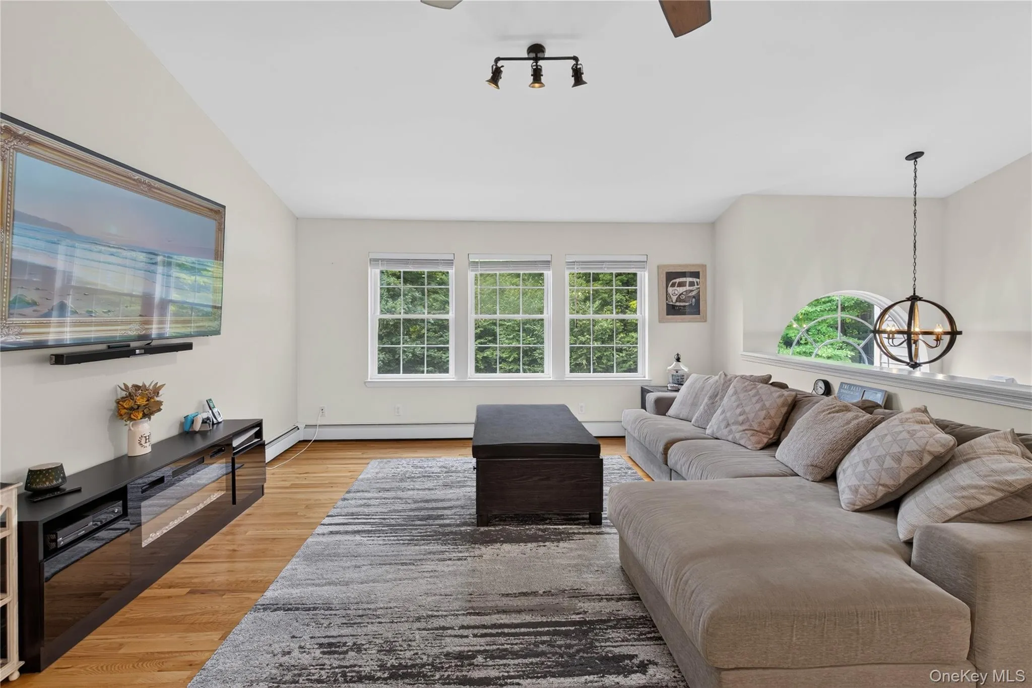 Hardwood flooring, recessed lighting, three large windows, vaulted ceiling, and a decorative arched window Hardwood flooring, recessed lighting, three large windows, vaulted ceiling, and a decorative arched window