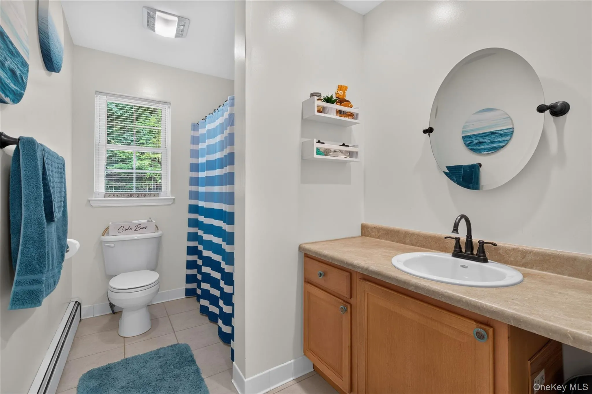 Bathroom with a vanity featuring a drop-in sink and wood-finish cabinetry Bathroom with a vanity featuring a drop-in sink and wood-finish cabinetry